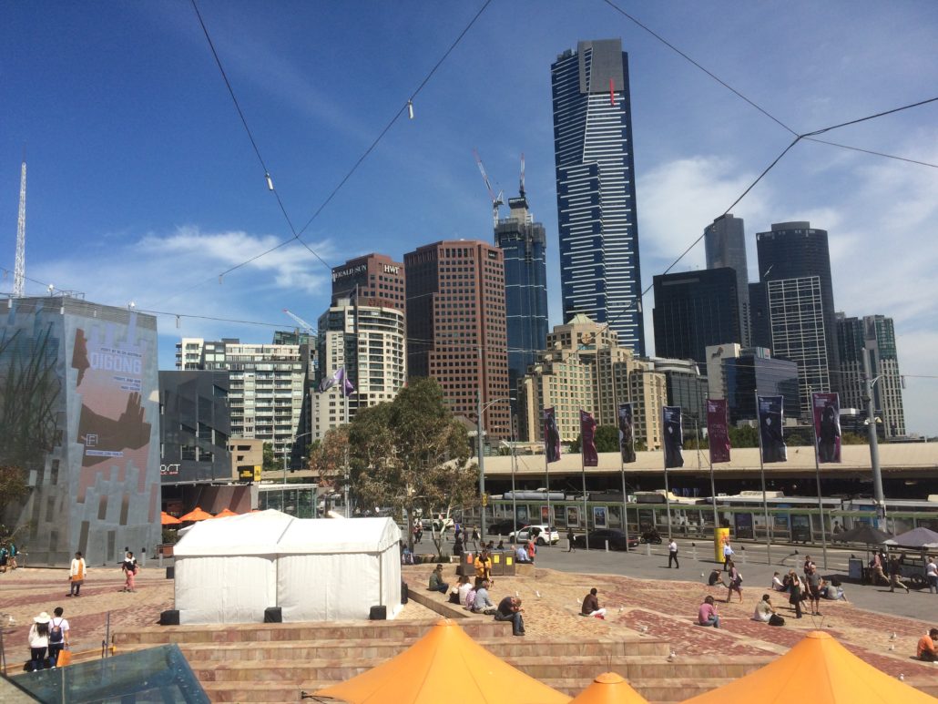 federation square, melbourne with skyscrapers in the background