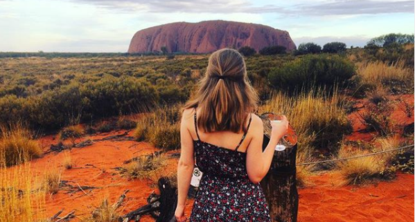 Jess standing in front of Ayers Rock admiring the view